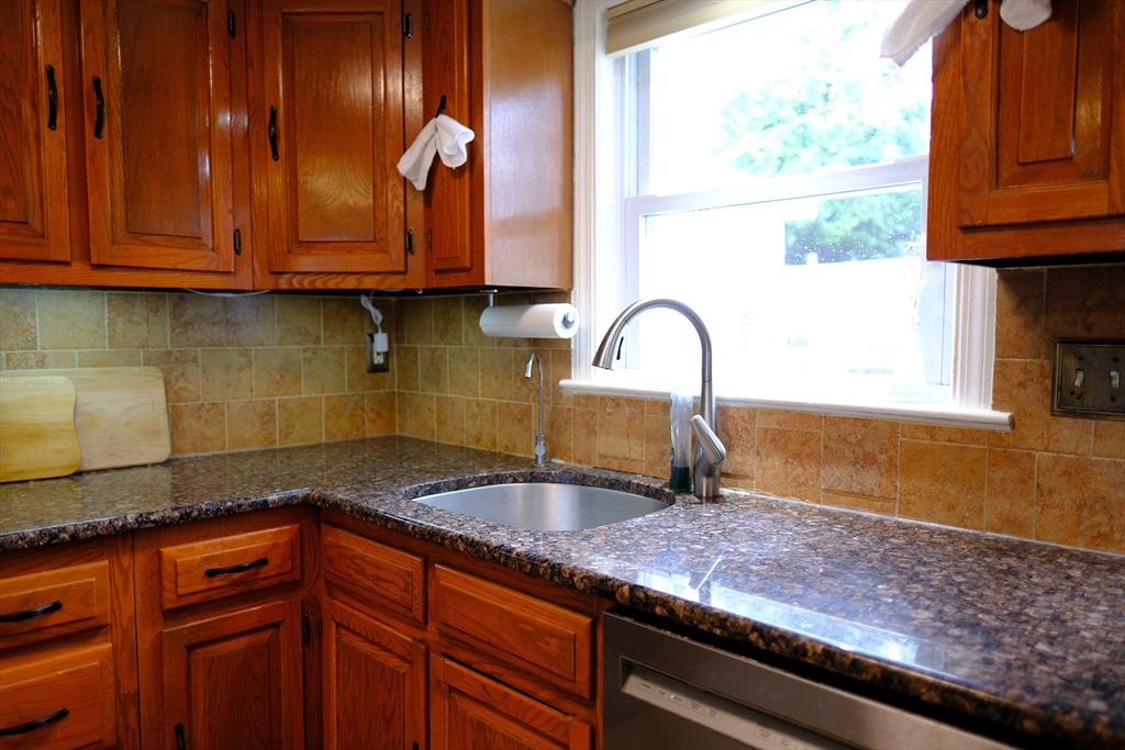 9 Stanley Street Natick, MA 01760 - Photo 18 of 42 a kitchen with granite countertop wooden cabinets a sink and dishwasher
