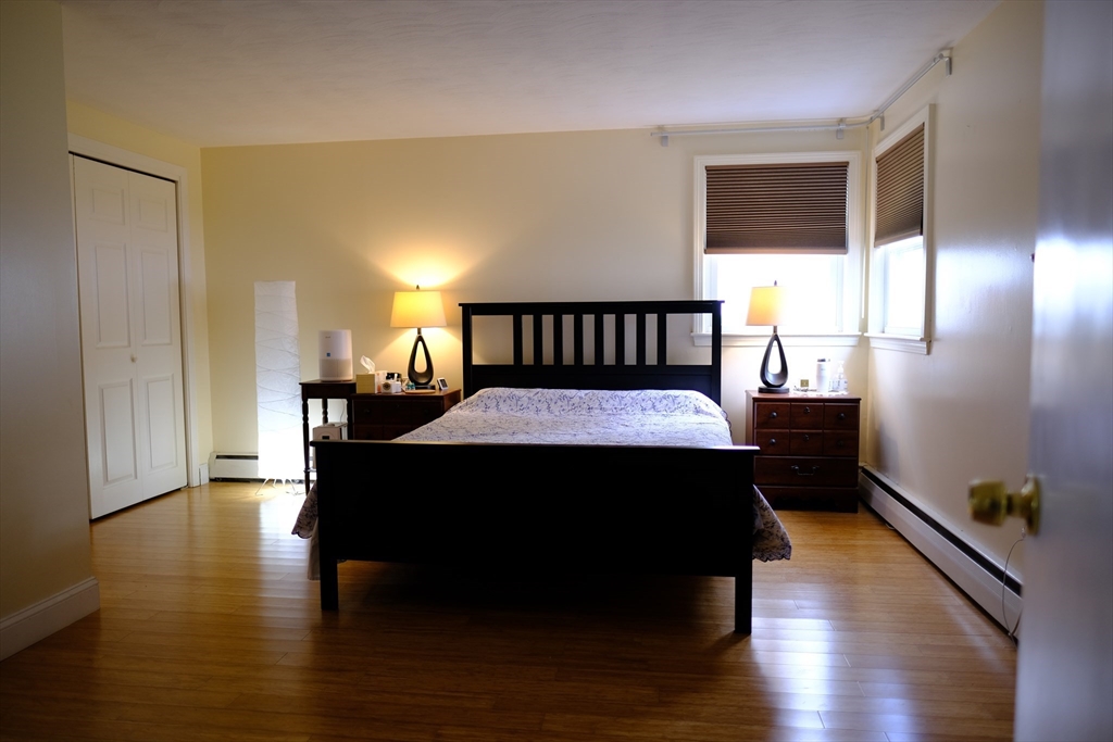9 Stanley Street Natick, MA 01760 - Photo 28 of 42 a bed sitting in a bedroom next to a window with wooden floor