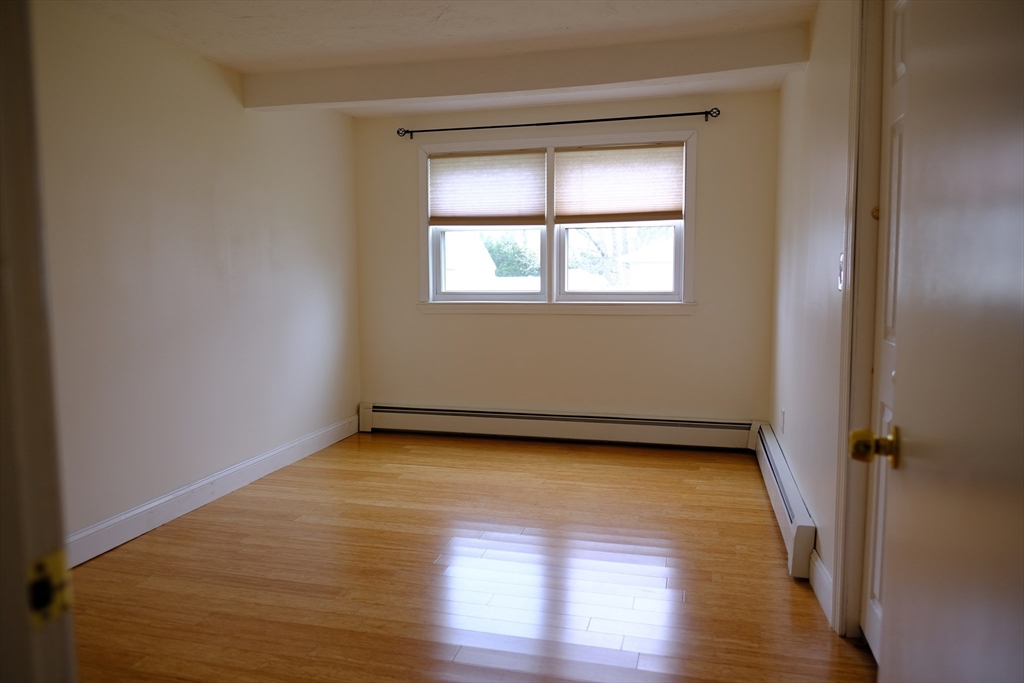 9 Stanley Street Natick, MA 01760 - Photo 29 of 42 an empty room with wooden floor and windows
