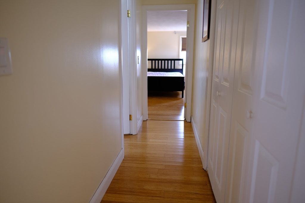 9 Stanley Street Natick, MA 01760 - Photo 31 of 42 a view of a hallway with wooden floor and staircase