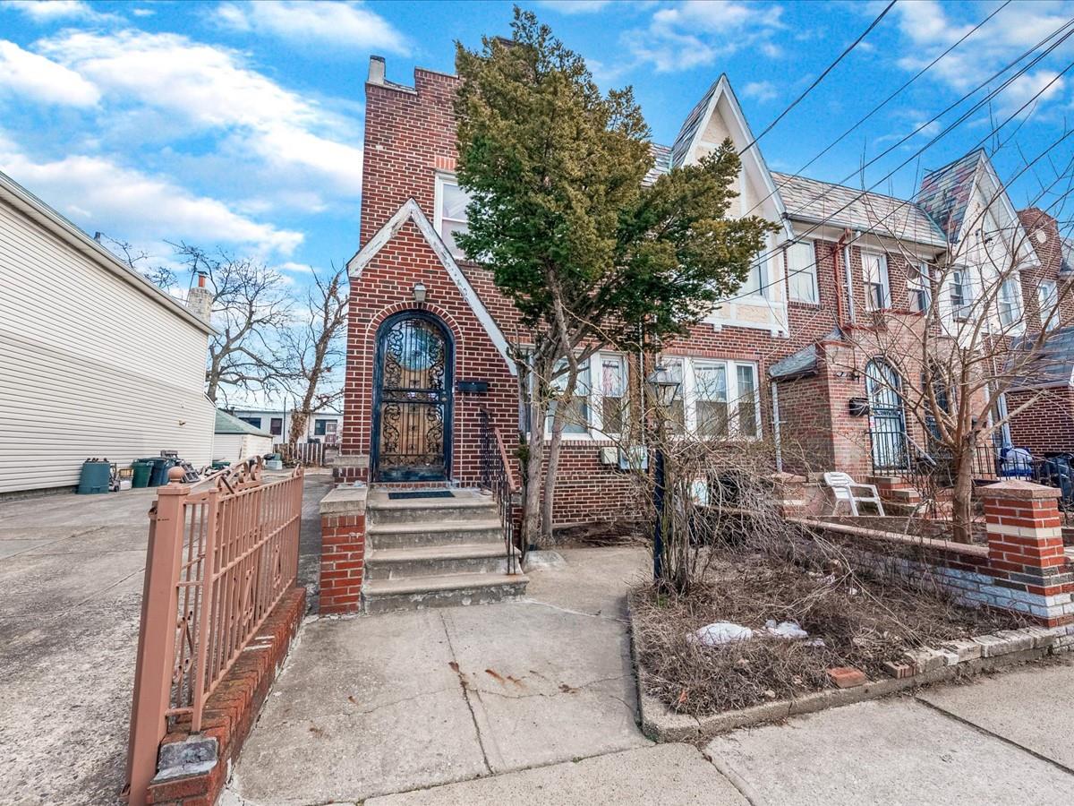 View of front of house with a fenced front yard and brick siding