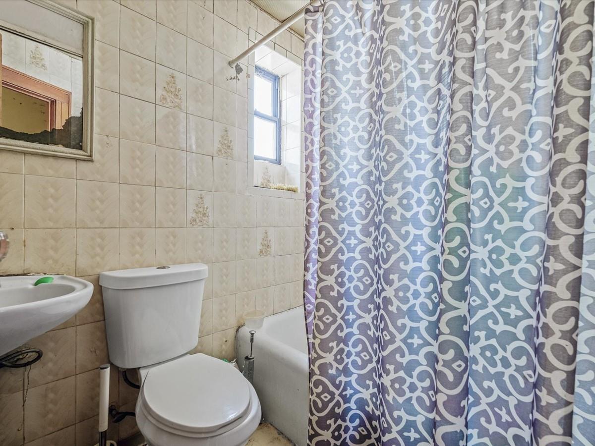 1775 Troy Avenue Brooklyn, NY 11234 - Photo 7 of 17 a white toilet sitting next to a shower curtain