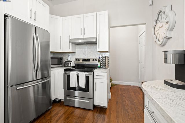 a kitchen with a refrigerator sink and cabinets