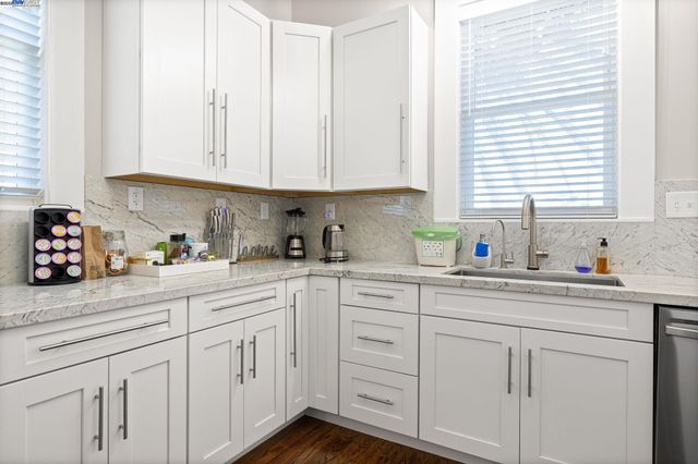 a kitchen with white cabinets and white appliances