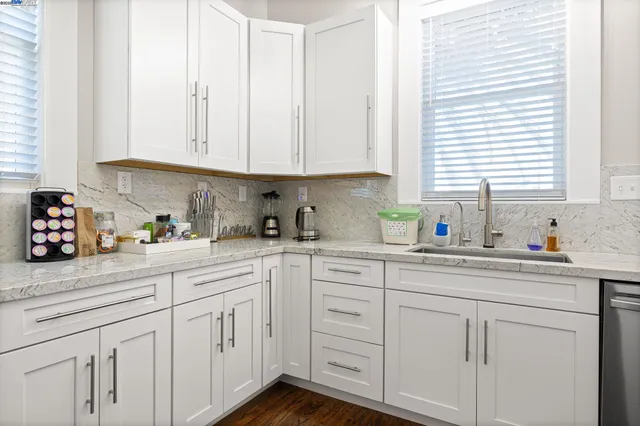 a kitchen with white cabinets and white appliances