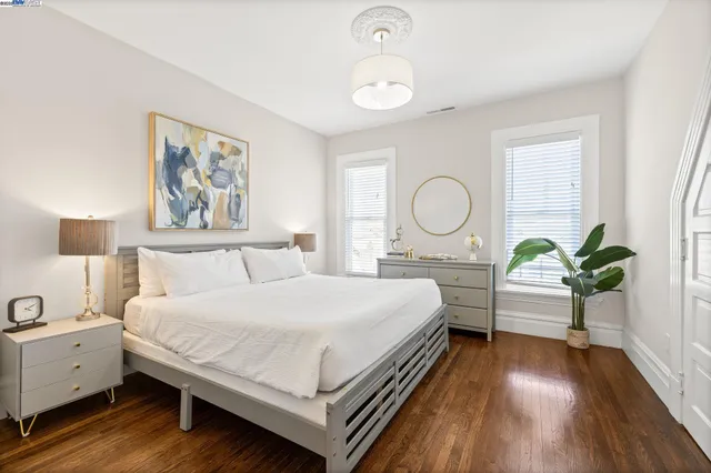 a bedroom with a bed chandelier and a window