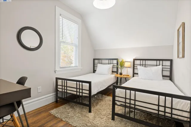 a bedroom with a bed a dresser and a window