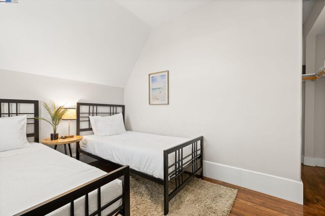 a bedroom with two beds and wooden floor