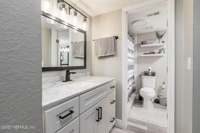 a bathroom with a granite countertop sink toilet and shower