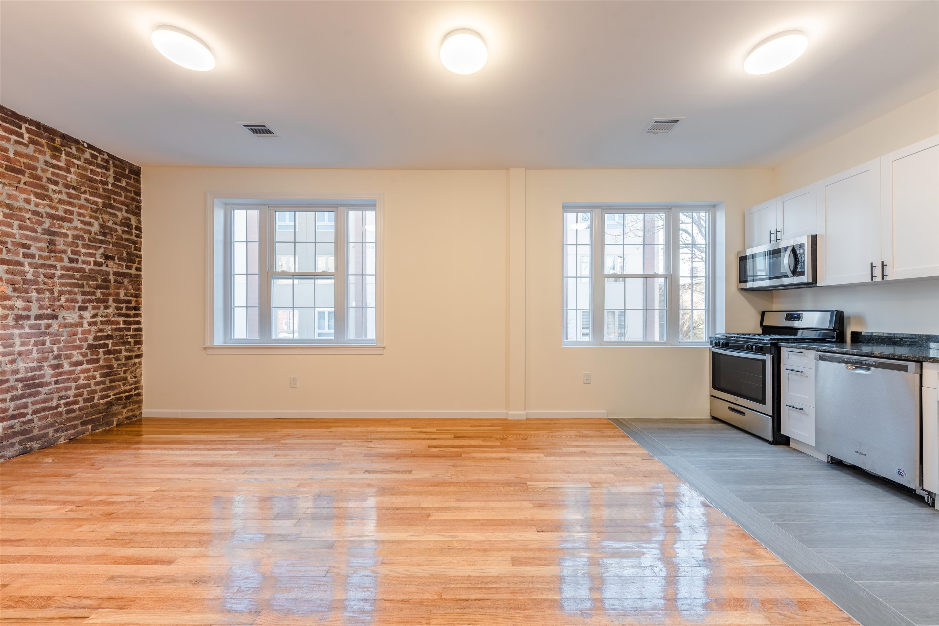 67 70th Street, Unit 2 Guttenberg, NJ 07093 - Photo 3 of 10 a view of kitchen with granite countertop cabinets and window