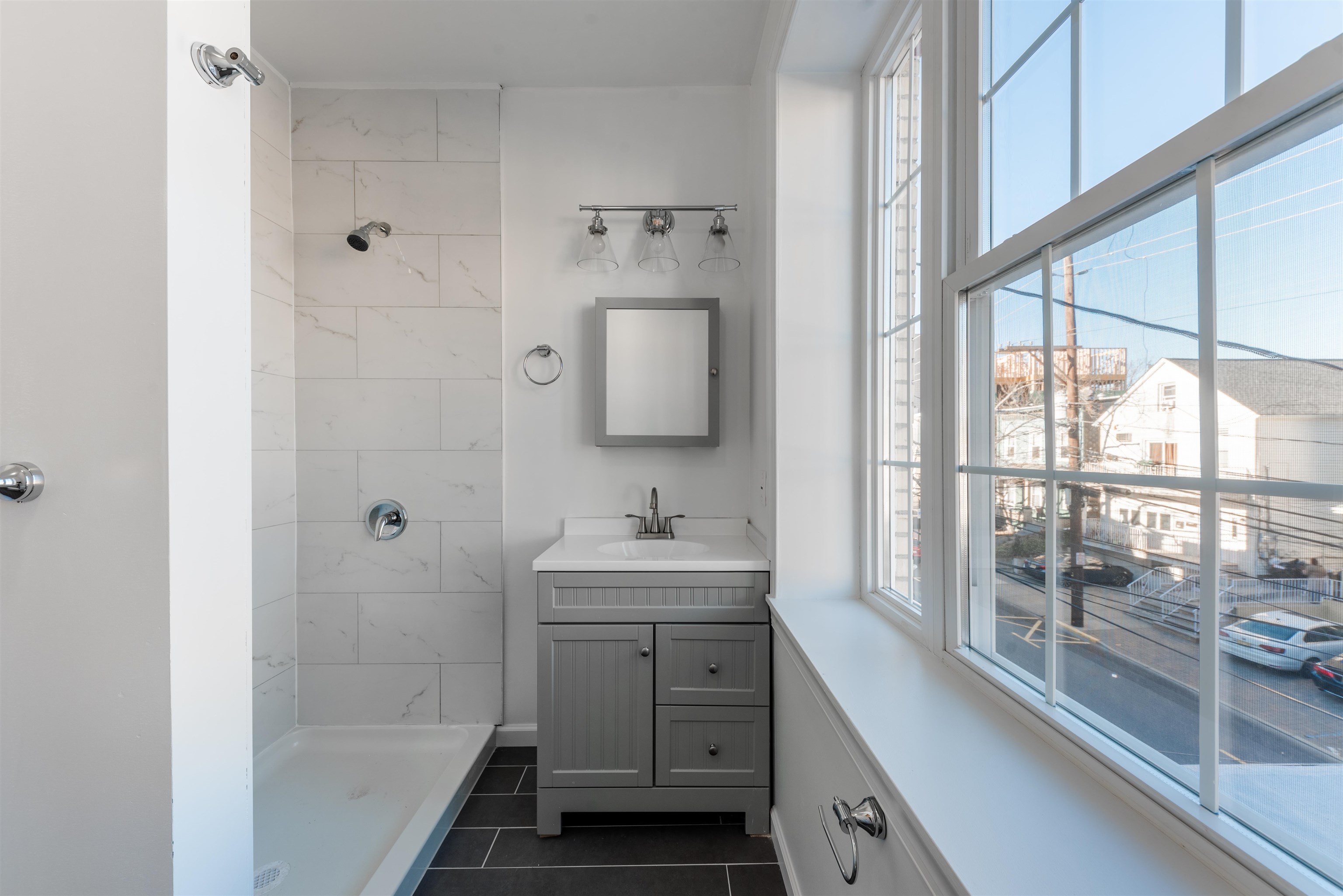 67 70th Street, Unit 2 Guttenberg, NJ 07093 - Photo 8 of 10 a bathroom with a sink a toilet and shower