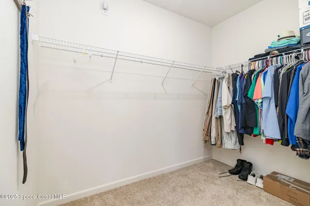 a view of walk in closet with clothes