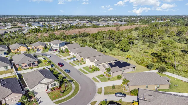 an aerial view of residential houses with outdoor space and trees