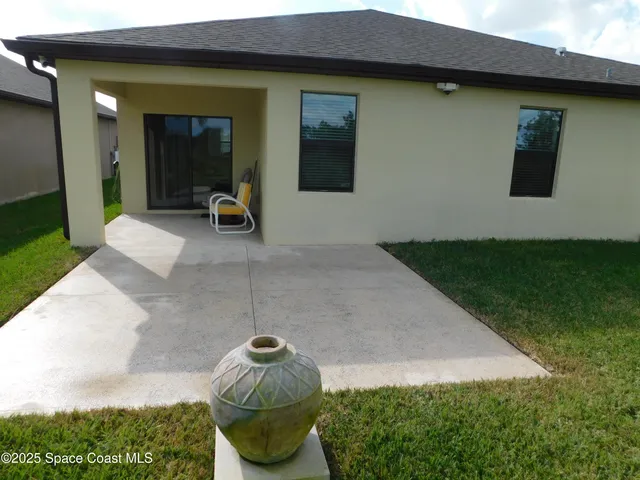 a view of a backyard with plants and brick wall