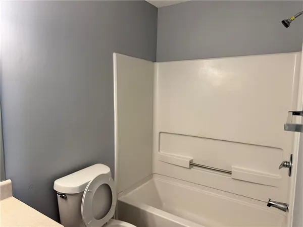 a white toilet sitting next to a shower