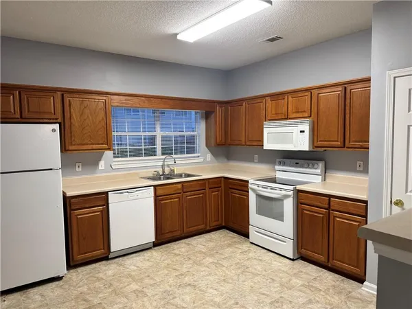 a kitchen with stainless steel appliances granite countertop a stove sink and cabinets