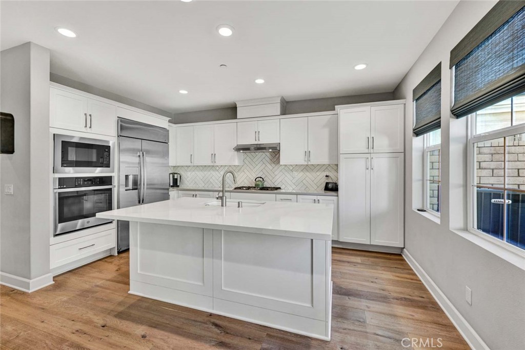 1270 Providence Loop Placentia, CA 92870 - Photo 11 of 59 Chef's kitchen showing center island with farmhouse sink and breakfast bar, plus side by side Refrigerator/Freezer
