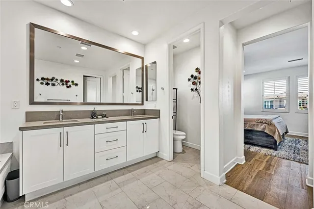 a bedroom with bed and paintings on the wall