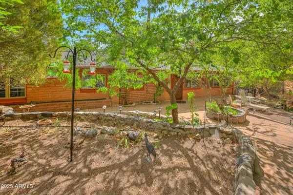 a front view of a house with a garden and tree