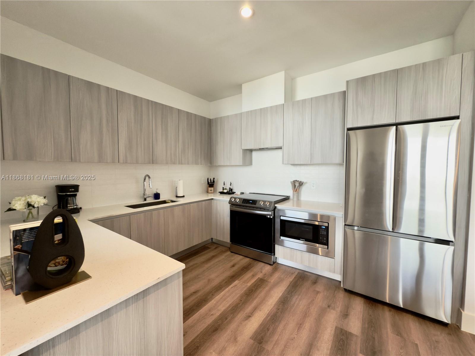 2800 Southwest 27th Terrace, Unit 610 Miami, FL 33133 - Photo 3 of 8 a kitchen with a refrigerator and a sink