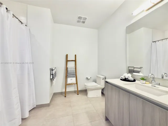 a bathroom with a granite countertop sink and a toilet