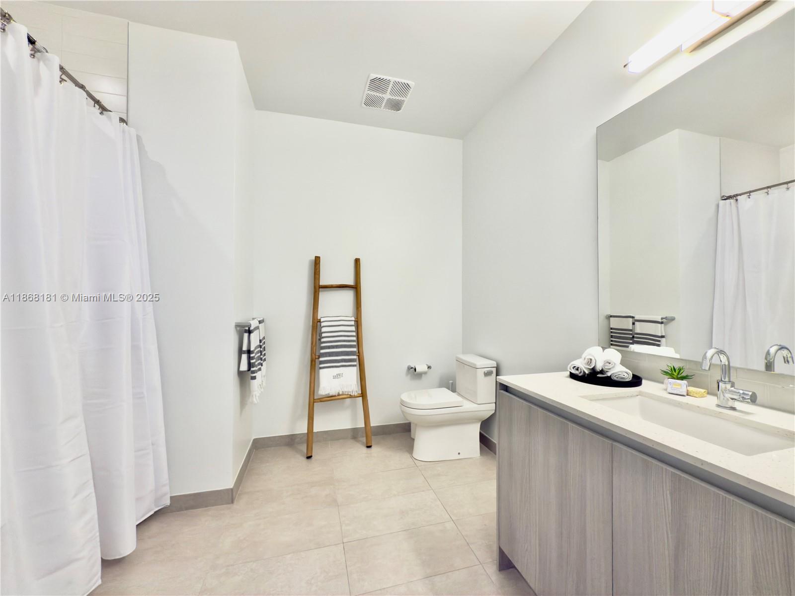 2800 Southwest 27th Terrace, Unit 610 Miami, FL 33133 - Photo 7 of 8 a bathroom with a granite countertop sink and a toilet