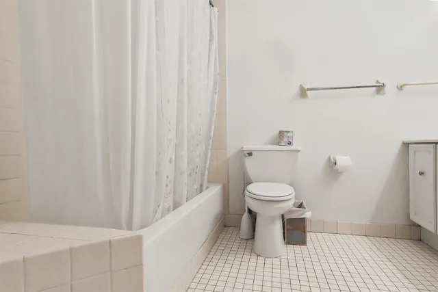 a bathroom with a toilet and a shower curtain