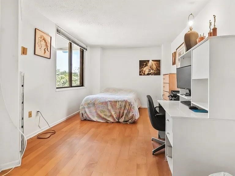 401 Harmon Cove Tower, Unit 401 Secaucus, NJ 07094 - Photo 24 of 49 a bedroom with a bed and wooden floor