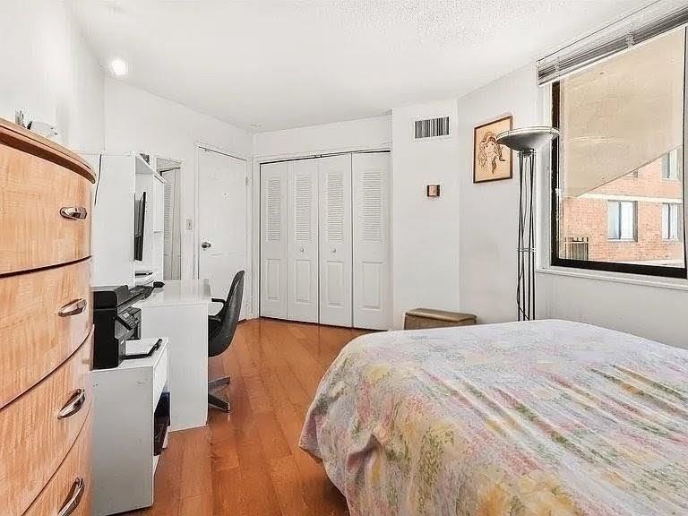 401 Harmon Cove Tower, Unit 401 Secaucus, NJ 07094 - Photo 25 of 49 a bedroom with a bed and wooden floor