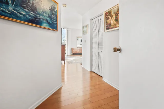 a view of a hallway with wooden floor and a living room