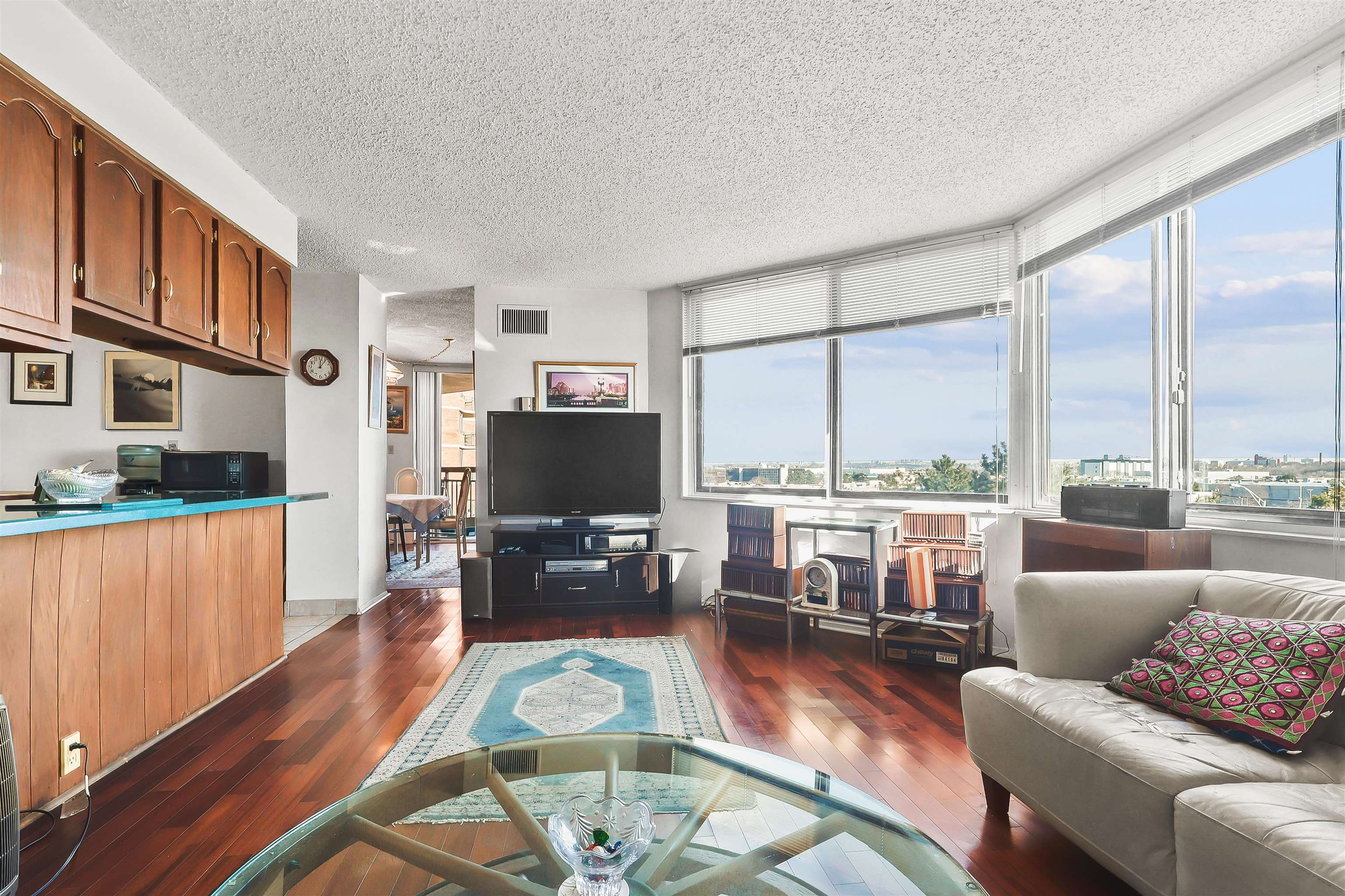 401 Harmon Cove Tower, Unit 401 Secaucus, NJ 07094 - Photo 6 of 49 a living room with furniture a rug wooden floor and a large window