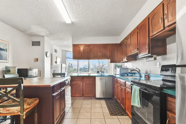 a kitchen with stainless steel appliances granite countertop wooden cabinets a stove top oven a sink and dishwasher