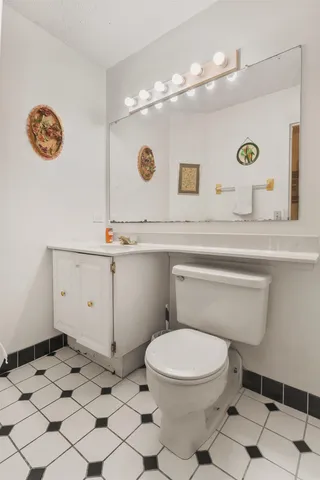 a bathroom with a sink a toilet and a mirror