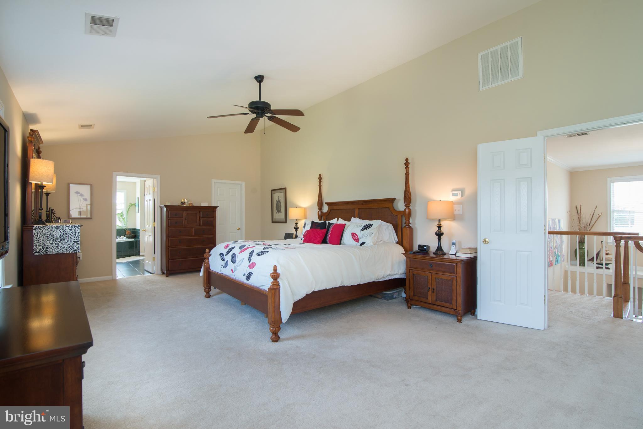 185 Rudder Road Shepherdstown, WV 25443 - Photo 22 of 30 a bedroom with a large bed a chandelier and a couch