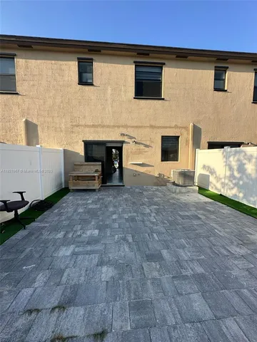 a backyard of a house with barbeque oven and brick wall