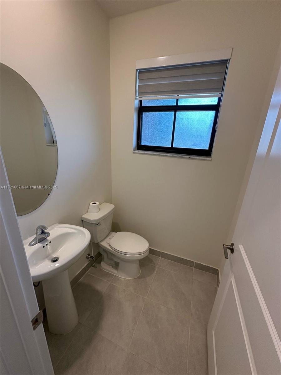 3302 West 114th Terrace Hialeah, FL 33018 - Photo 3 of 30 a bathroom with a toilet sink and mirror