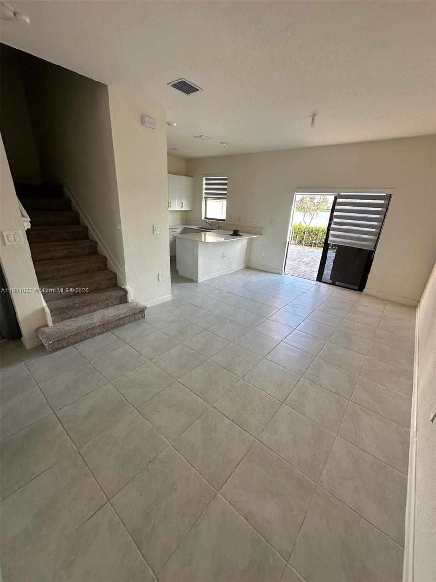 3302 West 114th Terrace Hialeah, FL 33018 - Photo 6 of 30 a view of kitchen and empty room with wooden floor