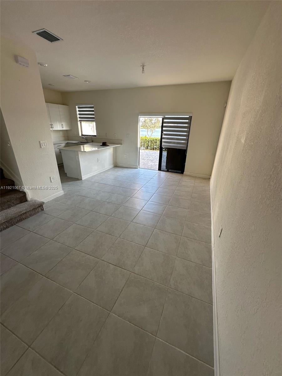 3302 West 114th Terrace Hialeah, FL 33018 - Photo 7 of 30 a view of empty room with wooden floor and fireplace