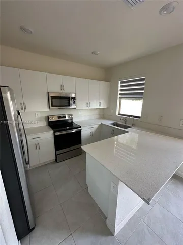 a kitchen with stainless steel appliances a refrigerator sink and microwave