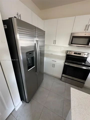 a kitchen with a refrigerator and a stove