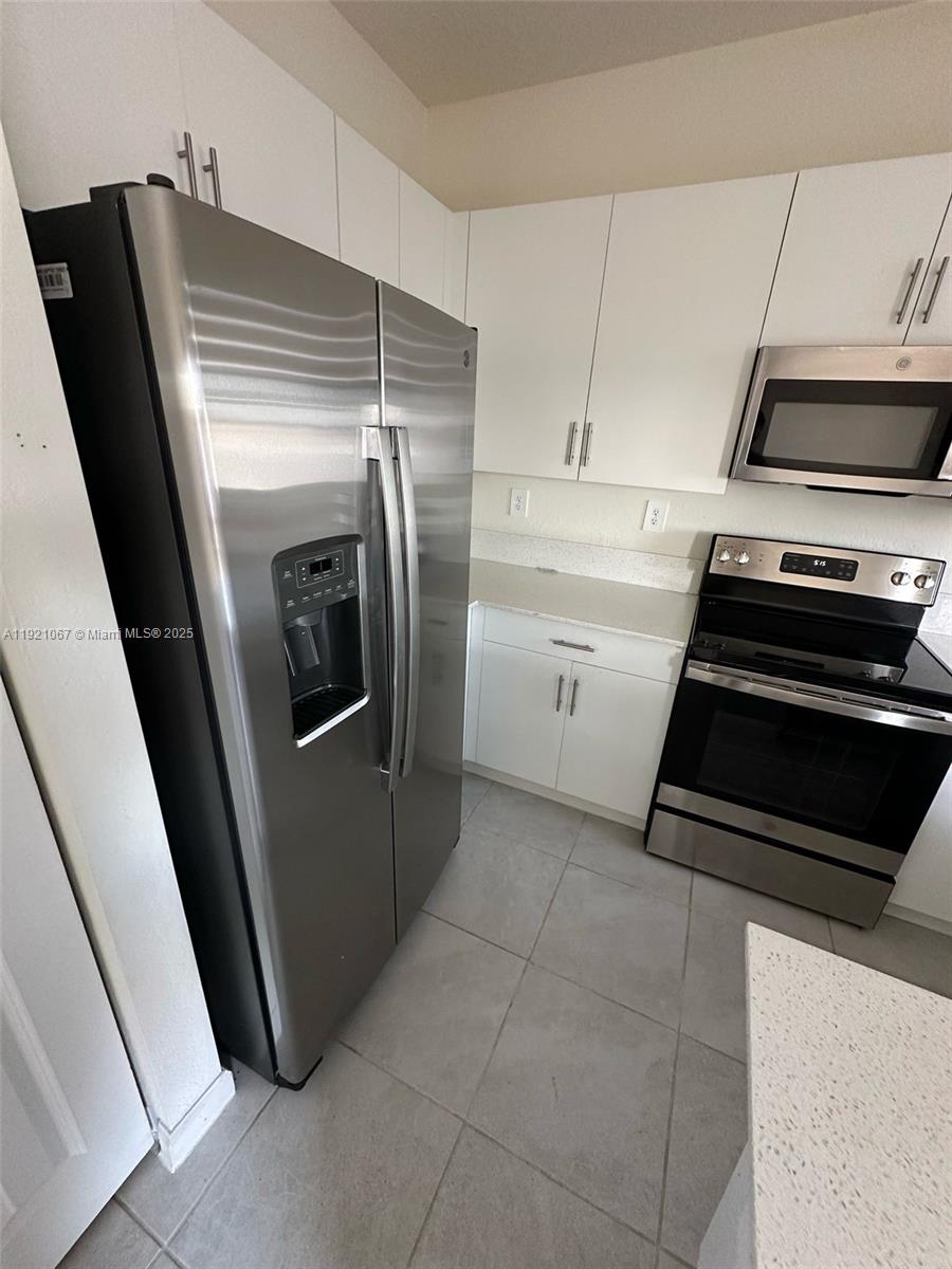 3302 West 114th Terrace Hialeah, FL 33018 - Photo 9 of 30 a kitchen with a refrigerator and a stove