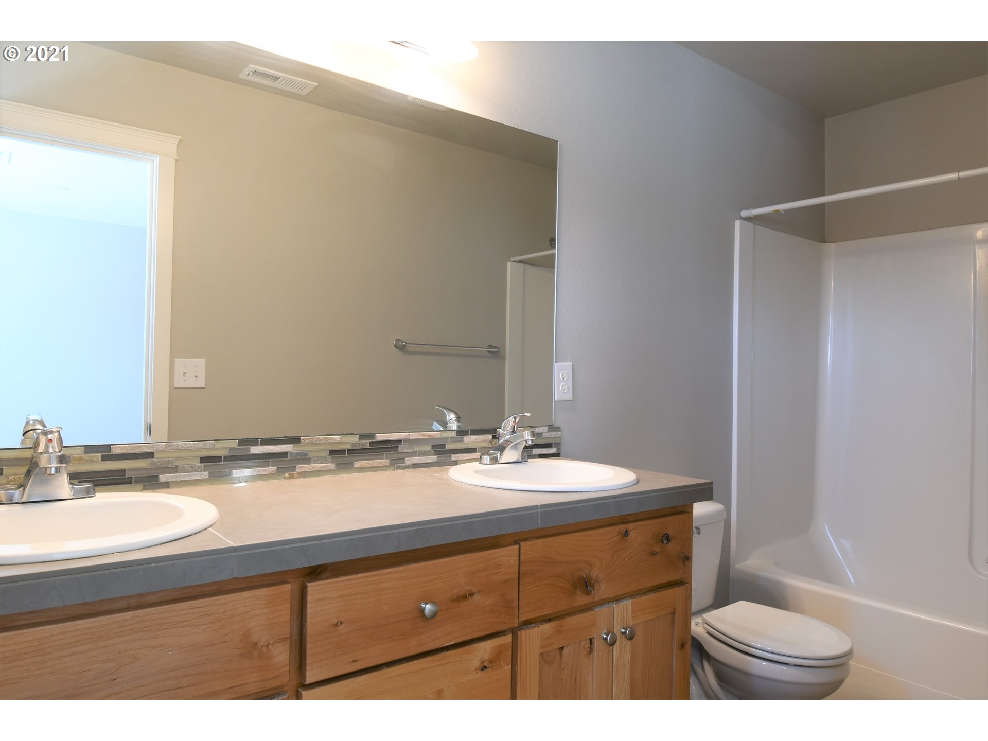 4361 North 2nd Way Ridgefield, WA 98642 - Photo 12 of 19 a bathroom with a sink a toilet a mirror and shower
