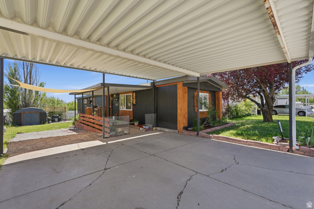 2500 North Fort Lane, Unit 220 Layton, UT 84041 - Photo 2 of 23 Carport offering covered parking and an exterior featuring dark panel siding with wood-finish accents