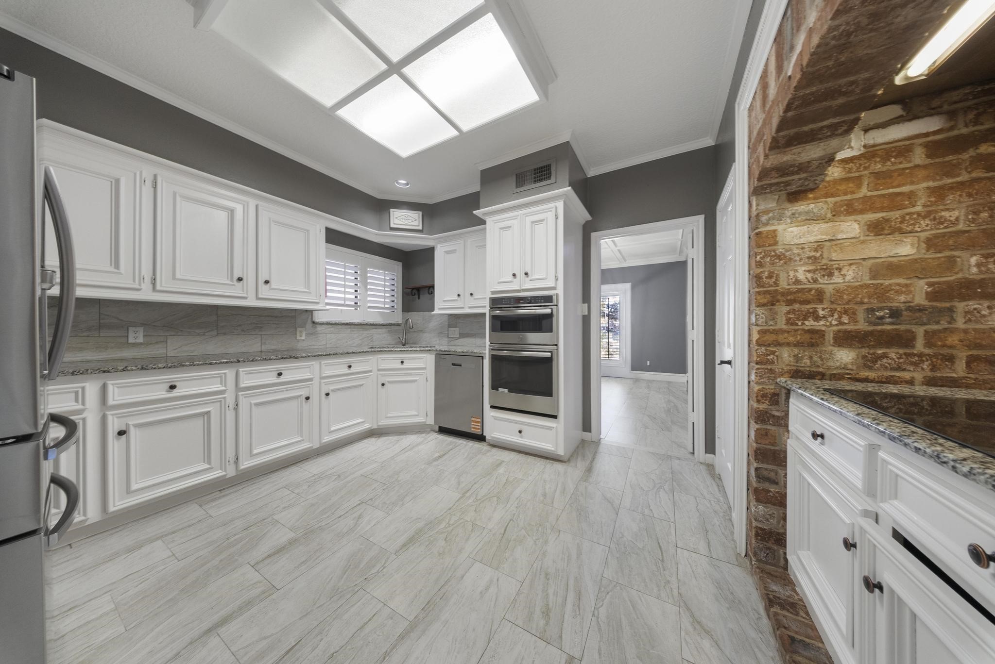 11626 Taos Lane Houston, TX 77070 - Photo 16 of 32 a large kitchen with cabinets wooden floor and stainless steel appliances
