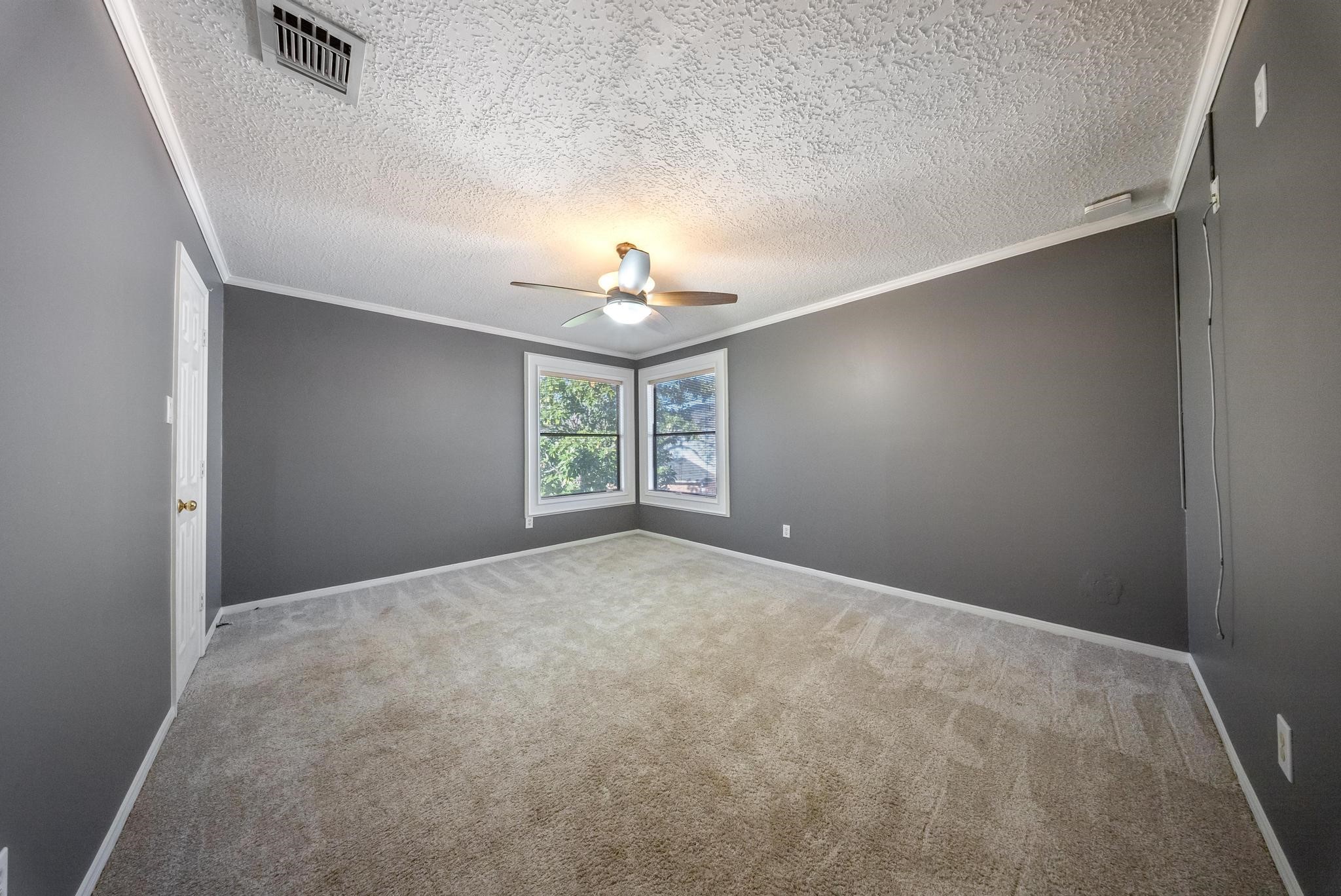 11626 Taos Lane Houston, TX 77070 - Photo 29 of 32 an empty room with windows and chandelier