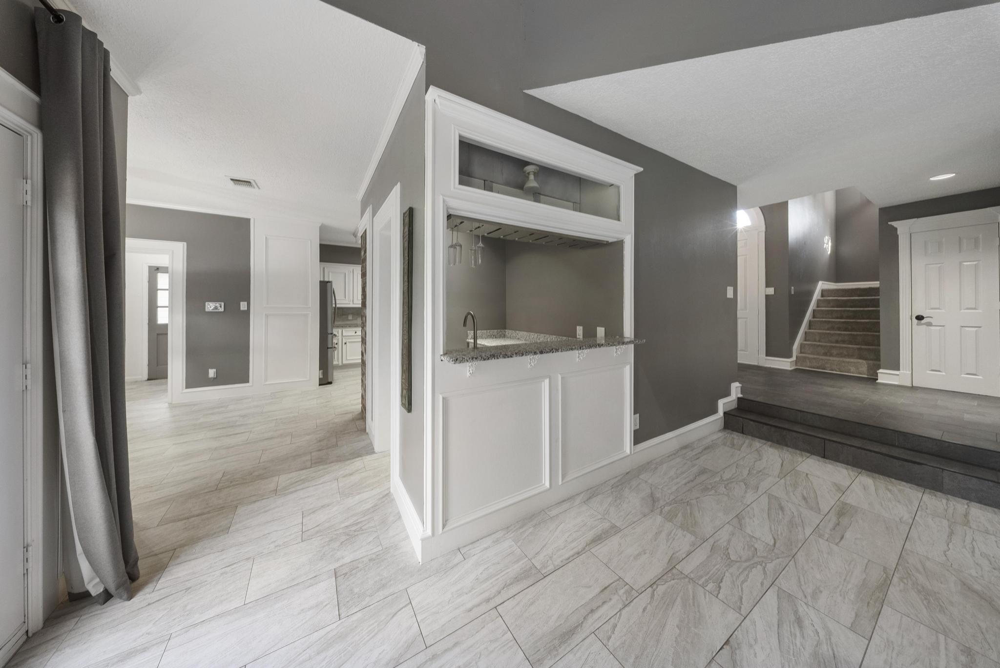 11626 Taos Lane Houston, TX 77070 - Photo 10 of 32 a view of a hallway with wooden cabinets and staircase