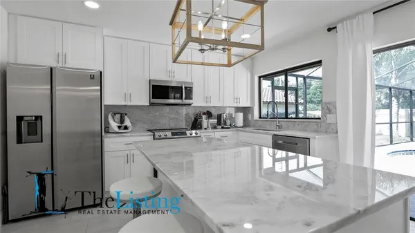 a view of kitchen with windows and refrigerator