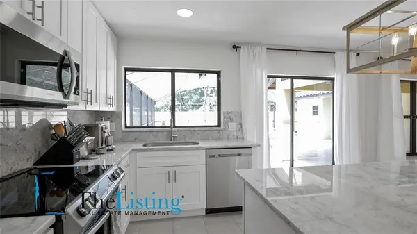 en suite bathroom with a granite countertop sink a mirror and a shower