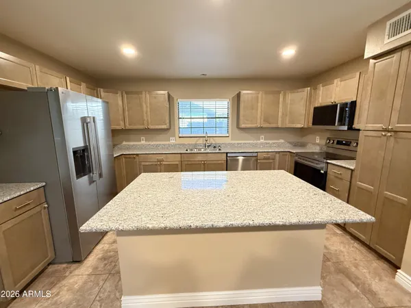 a kitchen with stainless steel appliances granite countertop a refrigerator stove microwave and sink