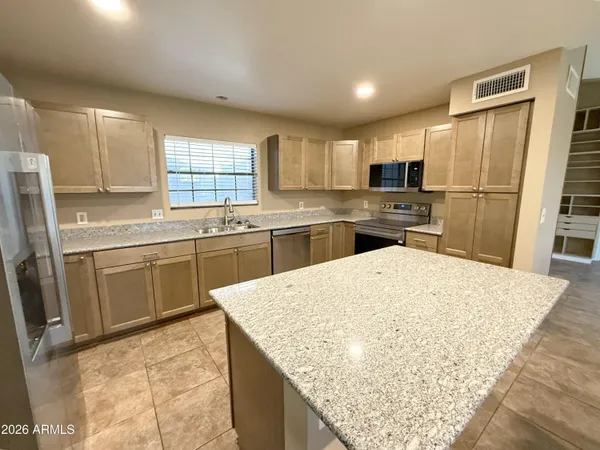 a kitchen with stainless steel appliances granite countertop a sink stove refrigerator and a window